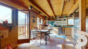 una cocina con mesa y sillas en una cabaña en Idyllic chalet in Evolène, with view on the Dent Blanche and the mountains en Evolène