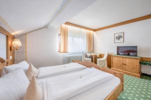 A bed or beds in a room at Gasthof Schroll