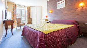 a bedroom with a bed with a red and yellow blanket at Hôtel Restaurant La Terrasse in Saugues