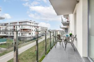 a balcony with a table and chairs and a view of a street at Apartamenty Osiedle Bursztynowe II by Renters in Kołobrzeg