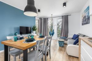 a dining room and living room with a table and chairs at Apartamenty Wyspa Solna by Renters in Kołobrzeg