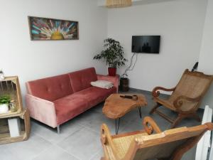 een woonkamer met een rode bank en stoelen bij Au Rythme de Concarneau in Concarneau