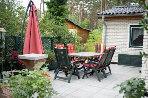 a patio with a table and chairs and an umbrella at Ferienhaus Matthies in Kolpinsee