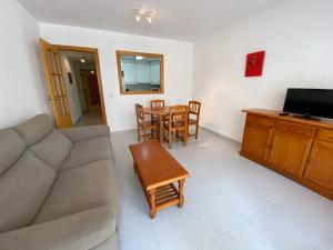 a living room with a couch and a table at Apartamentos Irta Playa Altamar in Alcossebre