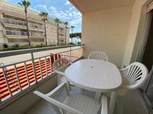 una mesa blanca y sillas en un balcón con vistas en Apartamentos Irta Playa Altamar, en Alcossebre