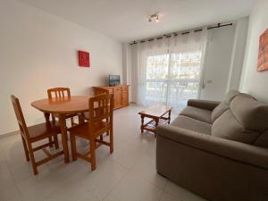 sala de estar con mesa y sofá en Apartamentos Irta Playa Altamar, en Alcossebre