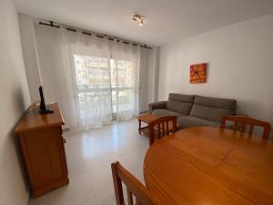 a living room with a couch and a table at Apartamentos Irta Playa Altamar in Alcossebre +1 photo