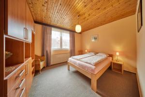 um quarto com uma cama e um tecto de madeira em Apartmán Svoboda em Svoboda nad Úpou