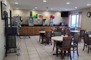 un restaurante con mesas y sillas y una cocina en Travelodge by Wyndham Fargo, en Fargo