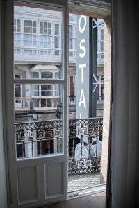 a window with a view of a building at Alda Alborán Rooms in A Coruña