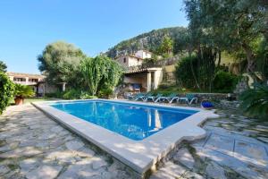 a swimming pool with chairs and a house at Can Moragues in Pollença