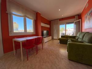 a living room with a table and a couch at Apartamentos Playa Del Moro III Altamar in Alcossebre