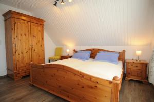 a bedroom with a large wooden bed with blue pillows at Apartmenthaus am Watt Büsum in Büsum