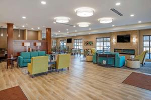 a lobby with a waiting area with blue and yellow chairs at Comfort Inn & Suites in Harrisonburg