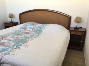 Una cama con un edredón blanco con flores. en Bord de mer - Cannes la Bocca, en Cannes