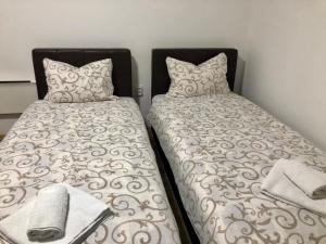 a bedroom with two twin beds with pillows at Prenoćište Vojkić in Sombor