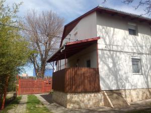 una casa blanca con una valla roja en Budai Vám Apartmanház, en Pécs