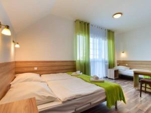 a bedroom with a large bed with green curtains at Nartorama HotRest in Zieleniec