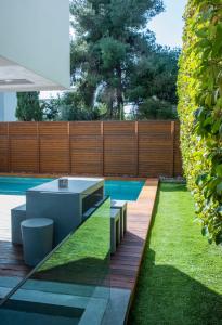 a backyard with a pool and a wooden fence at Elegant and Private Living by Neuvel in Athens