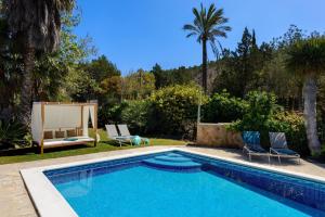 a swimming pool in a yard with two chairs at San Miguel Park in Sant Miquel de Balansat