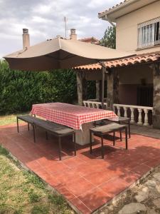 - une table de pique-nique et un parasol sur la terrasse dans l'établissement Chalet piscina privada Salamanca, à Calvarrasa de Abajo