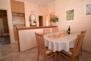 cocina y comedor con mesa y sillas en Guesthouse Kanjuo en Mlini