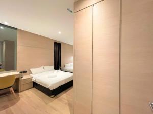 a bedroom with a bed and a desk and a mirror at Victoria Station Hotel Melaka in Melaka