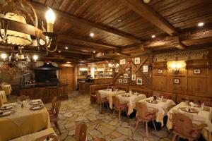 - un restaurant avec des tables et des chaises dans une salle dans l'établissement Hotel Mesdi, à Arabba