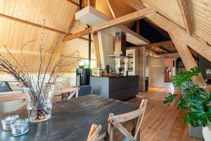 een keuken en eetkamer met een houten plafond bij Stroeckmanhoeve in Neede
