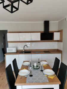 a kitchen with a wooden table with chairs around it at Robtom in Ostrowo