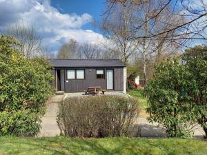 une petite maison avec un banc devant elle dans l'établissement Chalet l'Orvallée, à Virton