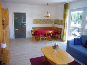 ein Wohnzimmer mit einem Tisch und einem blauen Sofa in der Unterkunft Haus Lucia Appartment "Schönblick" in Schönwald
