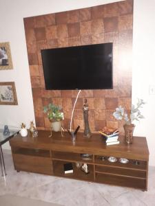 a flat screen tv on top of a wooden entertainment center at Casa Em Capitolio in Capitólio