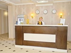 una mujer sentada en un mostrador en el vestíbulo en Villa Diego, en Rostov-on-Don
