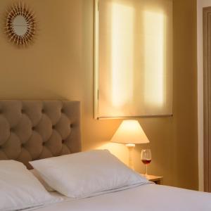 1 dormitorio con 1 cama con lámpara y ventana en Suite Home Santorini, en Fira