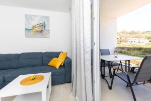 ein Wohnzimmer mit einem Sofa und einem Tisch in der Unterkunft Apartments Augustinovic in Baška