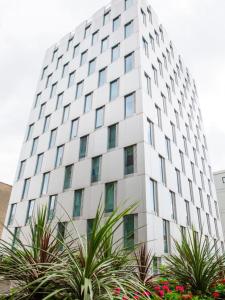 um edifício branco alto com plantas em frente em Chic Studios and Apartments at Chapter South Bank in London em Londres