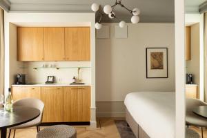 cocina y dormitorio con cama y mesa en Aparthotel Hattem en Hattem