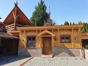 een houten huis met een voordeur en een oprit bij Kulacs Csarda Panzio in Eger