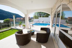 un patio al aire libre con sillas y una piscina en Villa Arion, en Mokošica