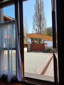 een open raam met uitzicht op een patio bij Kulacs Csarda Panzio in Eger