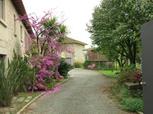 a garden with pink flowers on the side of a house at Casa Dos Tinocos in Braga