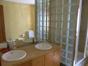 uma casa de banho com 2 lavatórios e um espelho grande em Casa Dos Tinocos em Braga
