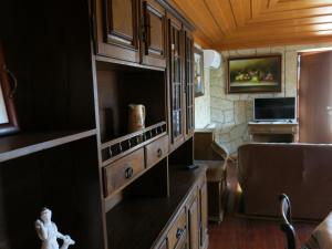a kitchen with wooden cabinets and a desk in a room at Casa Dos Tinocos in Braga