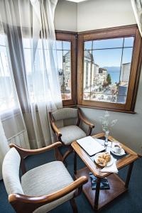 a room with a table and two chairs and a window at Hotel Nevada in San Carlos de Bariloche