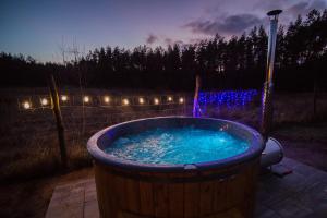 a hot tub in a yard at night with lights at Dom z bala Sosnowy in Mrągowo