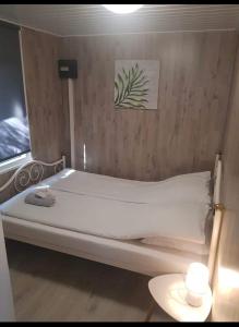 a bed in a room with a wooden wall at Cozy chalet in Opmeer near Amsterdam and Beach in Opmeer