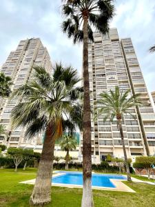 a hotel with palm trees in front of a building at Los Gemelos 20 - Aloturin Benidorm in Benidorm