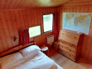 Highland Lodge في Kilmorack: غرفة نوم بسرير وخريطة على الحائط