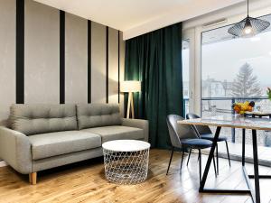 uma sala de estar com um sofá e uma mesa em Apartament Bóżnicza em Poznań